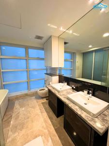 a bathroom with two sinks and a tub and a toilet at Platinum Suites KLCC by Dream'Inn in Kuala Lumpur
