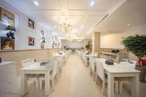 ein Esszimmer mit weißen Tischen und weißen Stühlen in der Unterkunft mingjia hotel in Yiwu