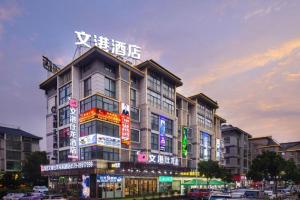 ein Gebäude mit Neonschildern an der Seite in der Unterkunft mingjia hotel in Yiwu