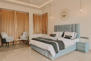 una camera da letto con un letto con due sedie e un tavolo di Casa Swarg a Parra Altre 36 foto