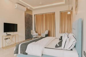 una camera da letto con un letto con due sedie e una televisione di Casa Swarg a Parra