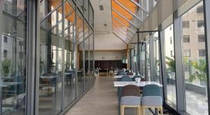 ein Flur mit Tischen und Stühlen in einem Gebäude in der Unterkunft ibis Styles Kunming Nanping Hotel in Kunming