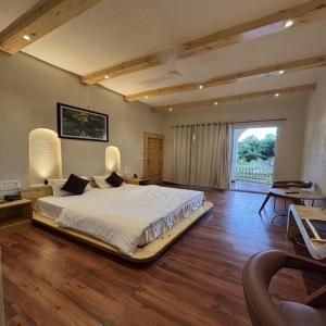 a large bedroom with a bed and a large window at Evaan Litchi Orchards and Resorts, Corbett in Rāmnagar