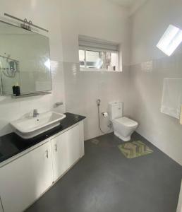ein weißes Badezimmer mit Waschbecken und Toilette in der Unterkunft Hagiazo Guest Inn Mirissa in Telangapata