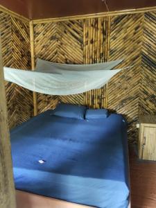 un letto a castello in una stanza con tetto di paglia e cuscini blu di The Last Resort a Don Det