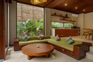 a living room with a green couch and a table at Nauma Ubud Villa in Ubud