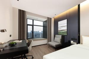 a hotel room with a desk and a bed at Atour Hotel Shanghai Wujiaochang Wanda Plaza in Shanghai +38 photos