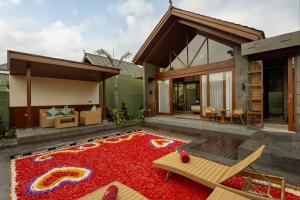 a patio with a large red rug in front of a house at Nauma Ubud Villa in Ubud