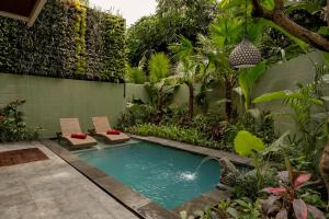 a swimming pool in the middle of a garden at Nauma Ubud Villa in Ubud