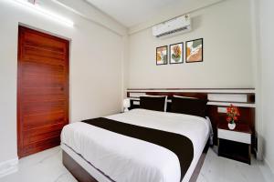 Un pat sau paturi într-o cameră la Collection O Aluva Kinfra Hi-Tech Park