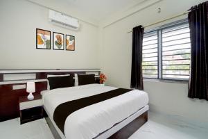 Un pat sau paturi într-o cameră la Collection O Aluva Kinfra Hi-Tech Park