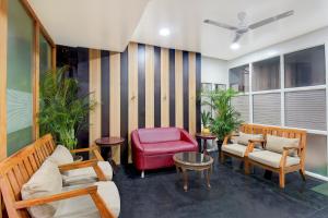 uma sala de estar com cadeiras e uma cadeira vermelha em Super Townhouse Viman Nagar Business Stay Formerly Silver Crest em Pune