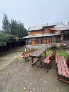three picnic tables in front of a building at Cazare muncitori Ploiesti -workers accommodation in Ţînţăreni