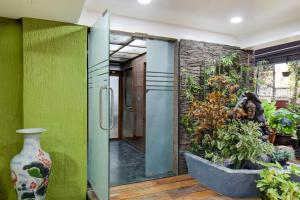 uma porta pivotante em uma sala com plantas em Super Townhouse Viman Nagar Business Stay Formerly Silver Crest em Pune mais 30 fotografias