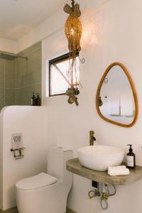 a bathroom with a toilet and a sink and a mirror at SAMPA El Nido in El Nido