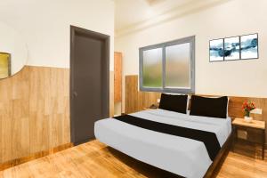 Ένα ή περισσότερα κρεβάτια σε δωμάτιο στο Townhouse Jagatpura Railway Station Formerly Hotel Buddhi