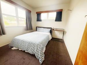 a bedroom with a bed with a black and white comforter at Peaceful Home Near Gardens, University & Downtown in Hamilton
