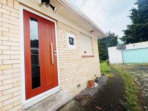 a red door on the side of a house at Peaceful Home Near Gardens, University & Downtown in Hamilton