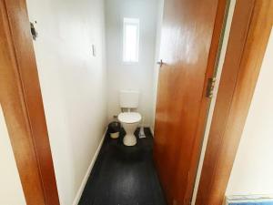 a small bathroom with a toilet and a door at Peaceful Home Near Gardens, University & Downtown in Hamilton +11 photos
