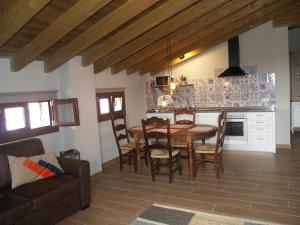 a kitchen and dining room with a wooden table and chairs at Etxekone in Guernica y Luno