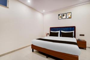 ein Schlafzimmer mit einem Bett in einem weißen Raum in der Unterkunft Super Townhouse Preet Vihar Metro Station in Neu-Delhi