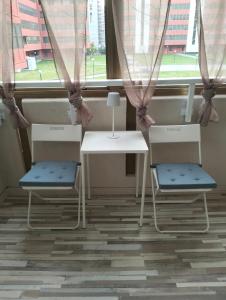 two chairs and a table in front of a window at GLI ELEMENTI Affittacamere Pieve Emanuele - HUMANITAS, IEO, MILANO CENTRO E FORUM ASSAGO in Pieve Emanuele