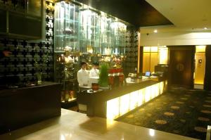a restaurant with two people standing behind a counter at Bell Tower Hotel in Xi'an