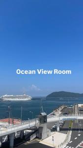 a bridge over the ocean with a cruise ship in the ocean view room at 海が見える隠れ家 -Tsukushi瀬戸内- in Takamatsu