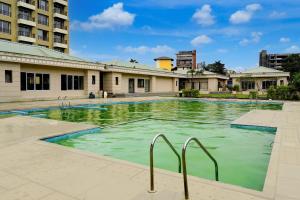 a swimming pool with green water in a building at Palette Hotel And Resort Igatpuri Formerly Bodh Valley Resort in Igatpuri
