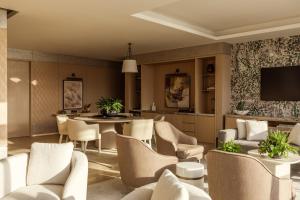 a living room with chairs and a dining room at Rosewood Doha in Doha