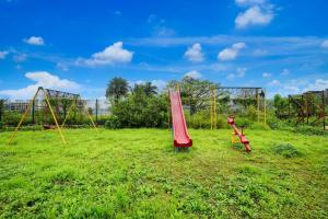 an empty playground with a red slide and swings at Palette Hotel And Resort Igatpuri Formerly Bodh Valley Resort in Igatpuri +29 photos
