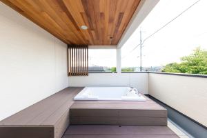 a bath tub sitting on a balcony with a window at Kotohaku 木津町 in Kizugawa