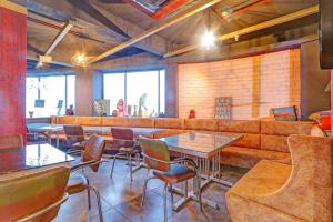 那格浦尔Palette Hotel and Resort Zero Mile Sitabuldi Formerly Gangakashi的有沙发和桌椅的餐厅