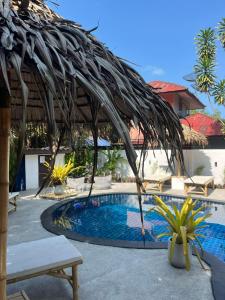 a resort with a swimming pool and a straw umbrella at Tropical Village Resort in Koh Samui 