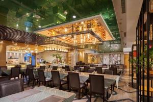 a restaurant with tables and chairs in a room at Yueyang Grand Skylight Hotel in Yueyang