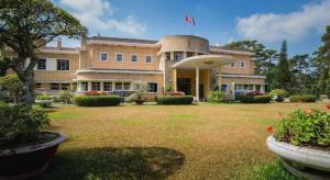 ein großes Gebäude mit einem großen Hof davor in der Unterkunft Gold Night Hotel in Da Lat