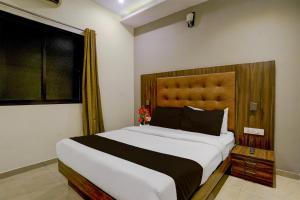 a bedroom with a large bed and a window at Super Townhouse Andheri Sakinaka Metro Formerly Hotel Amour in Mumbai