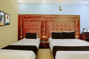 um quarto de hotel com duas camas e uma cabeceira em Super Townhouse Andheri Sakinaka Metro Formerly Hotel Amour em Mumbai