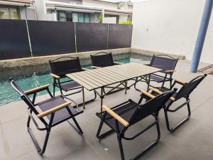 una mesa de picnic y sillas en un patio en Reflexion Puchong Private Pool Villa Group-Friendly, en Cyberjaya