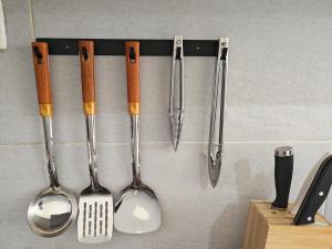 un grupo de utensilios colgados en una pared en Reflexion Puchong Private Pool Villa Group-Friendly, en Cyberjaya