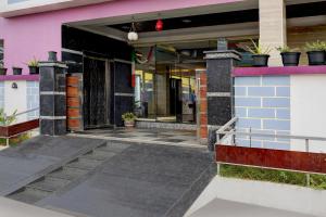 an entrance to a pink building with potted plants at Collection O Mini Bypass Nellore Road Formerly AMR Guest Inn in Nellore