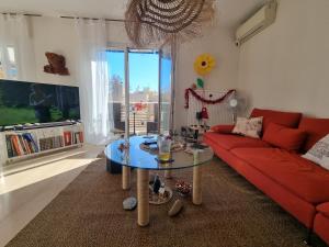 a living room with a red couch and a glass table at Chambres d'hôtes - Bed & Breakfast - chez Denis-Jo in Toulon
