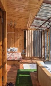a bedroom with a bed in a room with wooden walls at Skyview Jacuzzi Treehouse Power Backup Tandi in Kulu