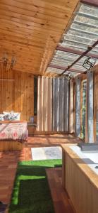 a bedroom with a bed and a green rug at Skyview Jacuzzi Treehouse Power Backup Tandi in Kulu