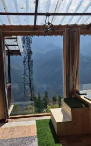 a large window with a view of a mountain at Skyview Jacuzzi Treehouse Power Backup Tandi in Kulu +10 photos