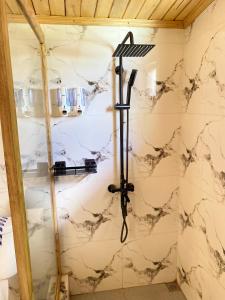ducha en una habitación con pared de mármol en Bara Village Guest House Bira, en Bira