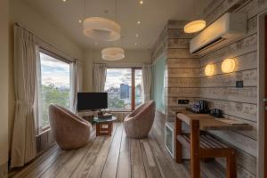 una camera con due sedie, una scrivania e una televisione di De Glance Hotel, Near Surat Railway Station a Surat