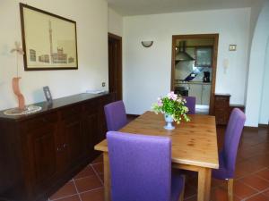 Villa Righino في مورلو: غرفة طعام مع طاولة خشبية وكراسي أرجوانية