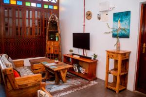 ein Wohnzimmer mit Tisch und Fernseher in der Unterkunft Kay's place Trainhouse apartments in Zanzibar City