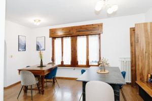 a dining room with a table and chairs and a window at Clos du Pinot by Hili in Aosta +34 photos